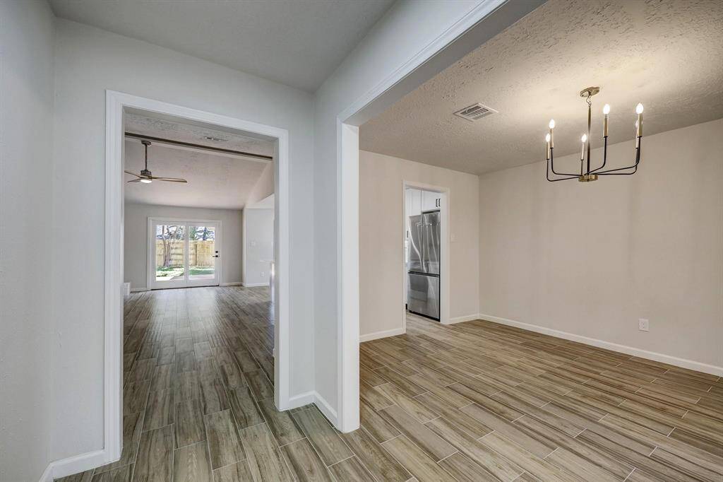 Upon entry, a clear line of sight leads through the open floor plan. The formal dining space is positioned to the right, while the vaulted living area unfolds ahead, drawing attention with its openness and natural light.