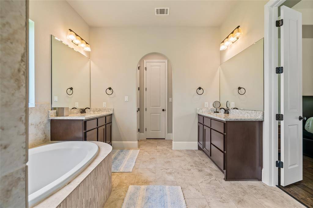 This elegant shower features polished beige marble tiles, a built-in shelf for storage, and a corner bench for comfort, accented by modern fixtures.  This shower is HUGE!