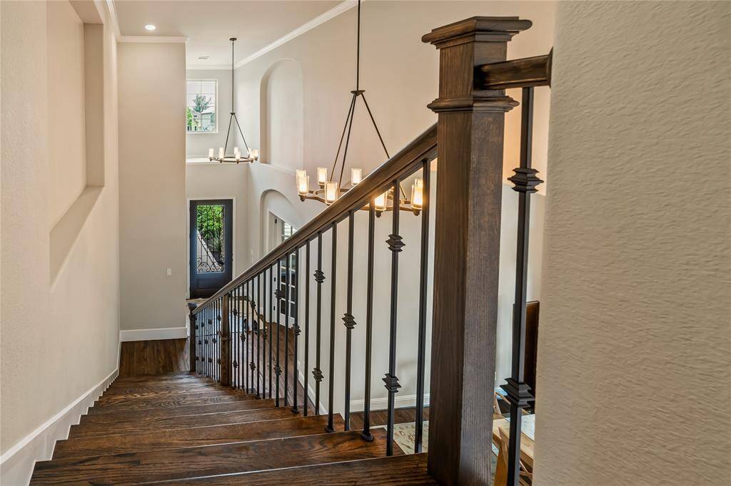 This spacious game room features elegant wood flooring, a vaulted ceiling with a fan, and ample natural light from large windows with shutters. The open layout includes a game area with a ping pong table, making it perfect for recreation and entertaining.