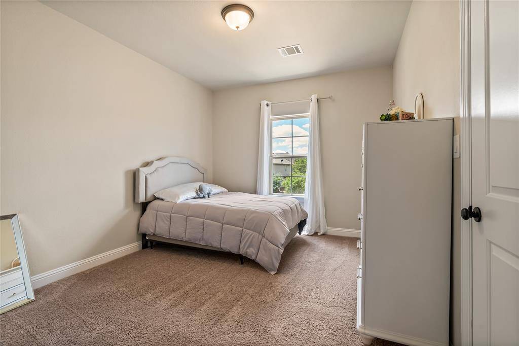 This bathroom features a clean, modern design with a tiled shower-bathtub combo, a sleek vanity with a single sink, and a large mirror. It includes a metal storage rack for towels and essentials, creating a functional and stylish space.  There is a bathroom for every bedroom.