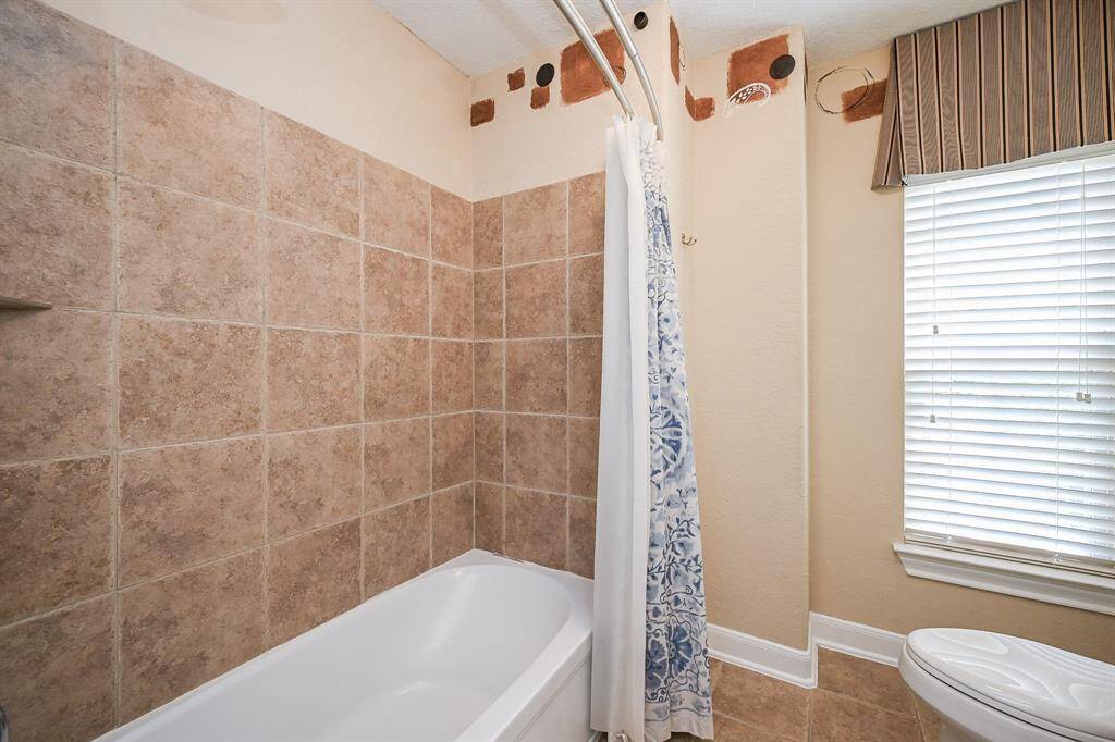 This spacious ensuite bath serves a secondary bedroom.