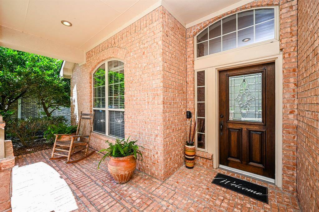 The bright, brick elevated, covered front porch is shared with a magnificent front door, for special welcomes.