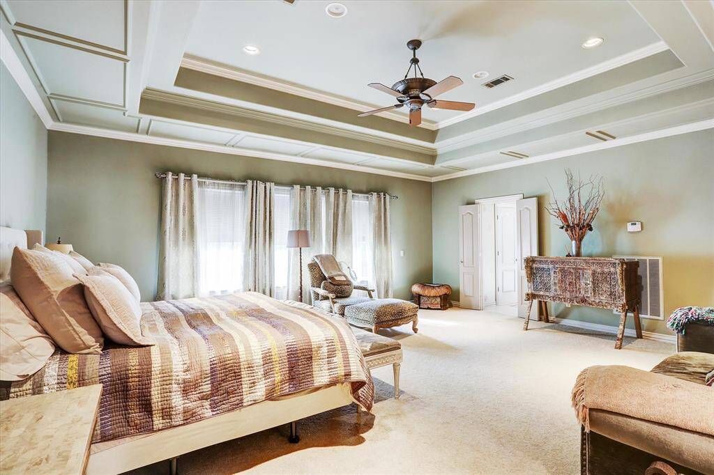 The large primary suite has beautiful tray ceilings and room for a sitting area. Please note, since these photos were taken the carpet has been removed and replaced with engineered hardwood floors (per seller).