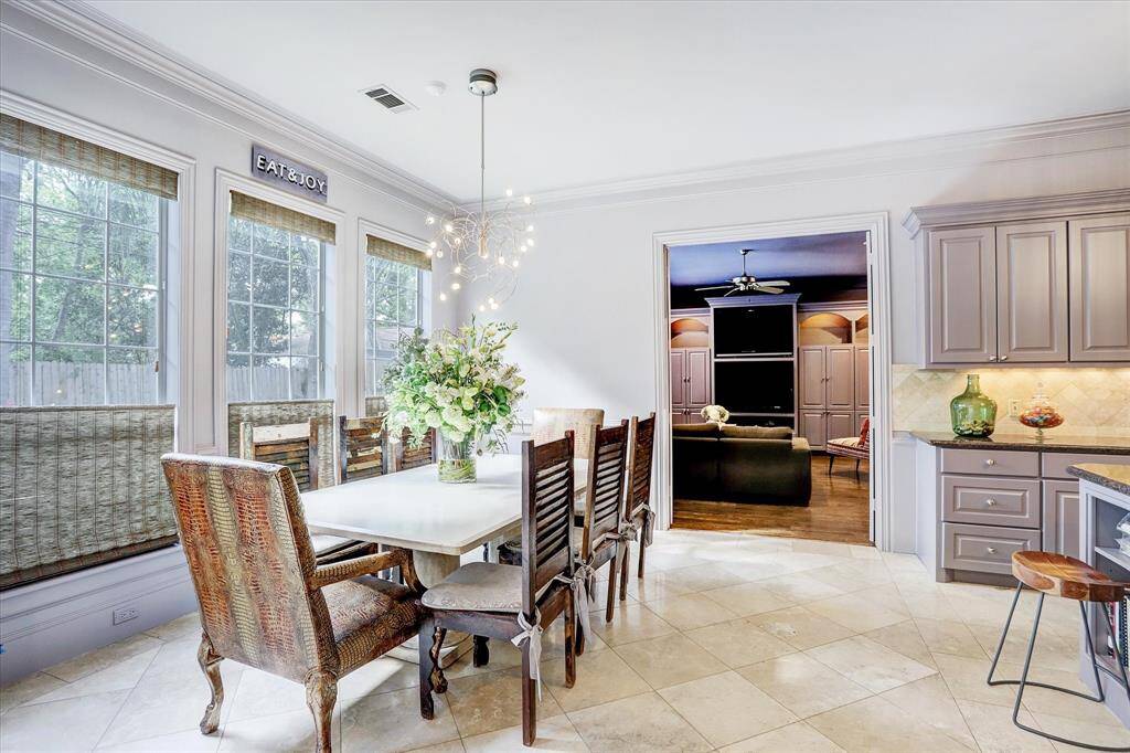 The large breakfast room off of the kitchen, with windows overlooking the backyard and pool.