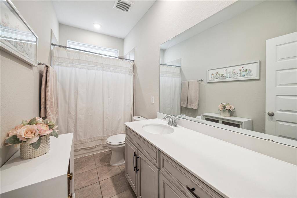 This full bathroom services the two secondary bedrooms and game room upstairs, which features pretty tile floors and crisp white countertops.