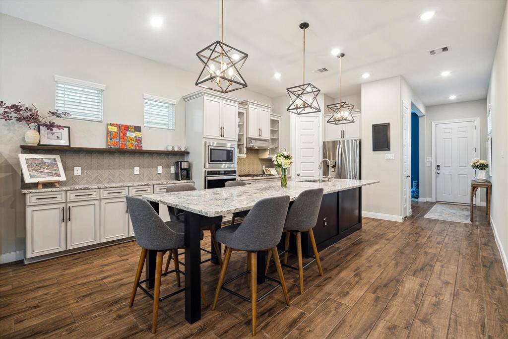 Another view of this beautiful kitchen reveals an abundance of storage with plenty of counter space and cabinetry. It's the perfect area for a coffee bar or to keep your kitchen essentials organized while maintaining a sleek and tidy look.
