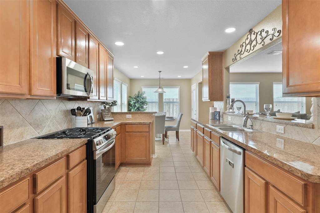 The kitchen has been recently updated with new stainless steel Frigidaire appliances including a 5 burner gas cooktop with a single oven and a vent hood microwave. Also, note the dual basin sink with a touchless gooseneck faucet and reverse osmosis water filtration.