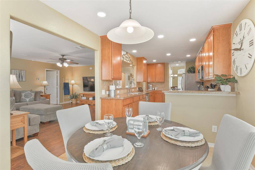 Tucked between the family room and the kitchen, there is a casual eat-in breakfast room anchored by a single pendant light above the table space. You'll enjoy easy maintenance tile floors and two walls of sunlit windows with 2-inch blinds.