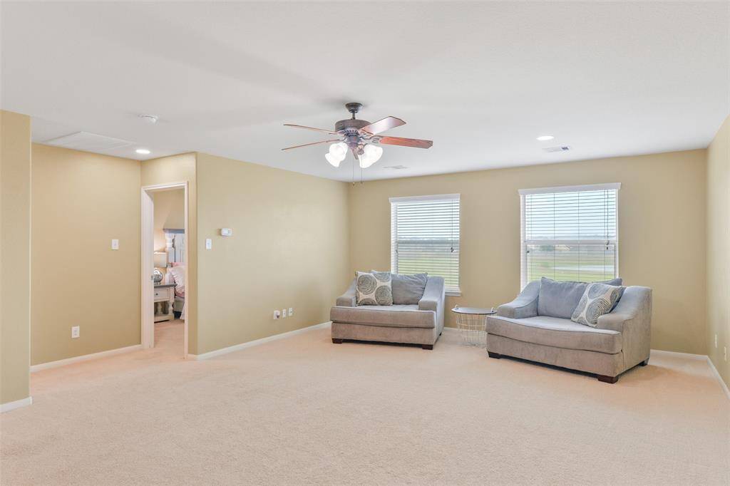 A carpeted staircase leads from the front foyer up to this large game room that's perfect for kids' toys, game nights, or movie dates! Note the plush new carpet, adjustable LED lighting, neutral paint, walk-in attic access, and windows with green space views.