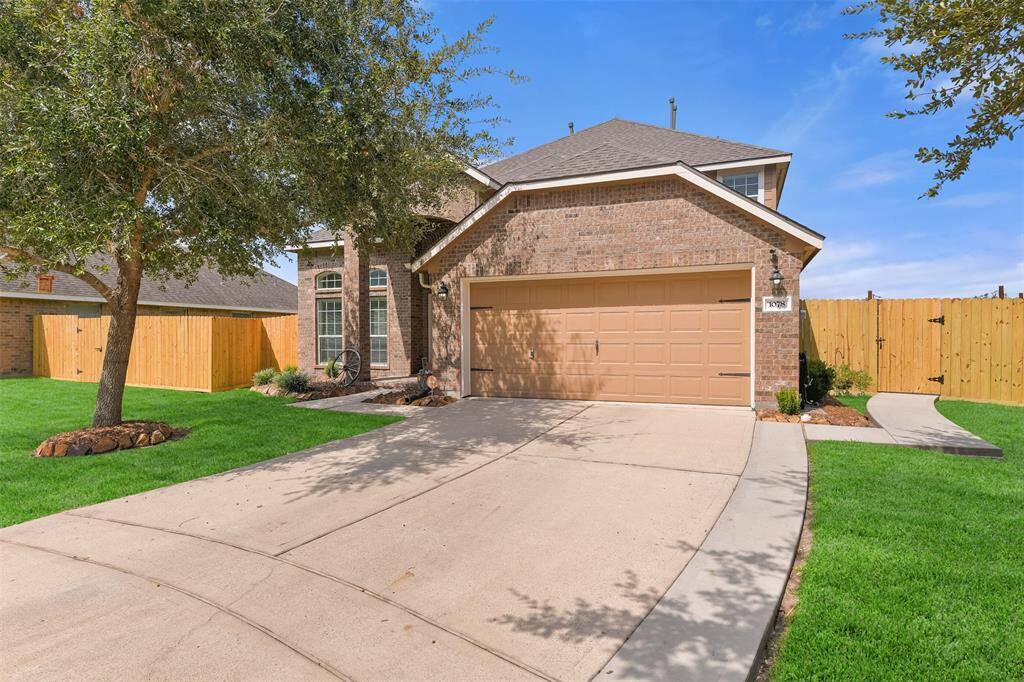 A six-panel front door with an electronic lock opens from the covered front porch into this airy and inviting foyer with an elevated ceiling, sunlit transom windows, neutral beige paint, durable tile floors, and a wide entrance to the dining room.