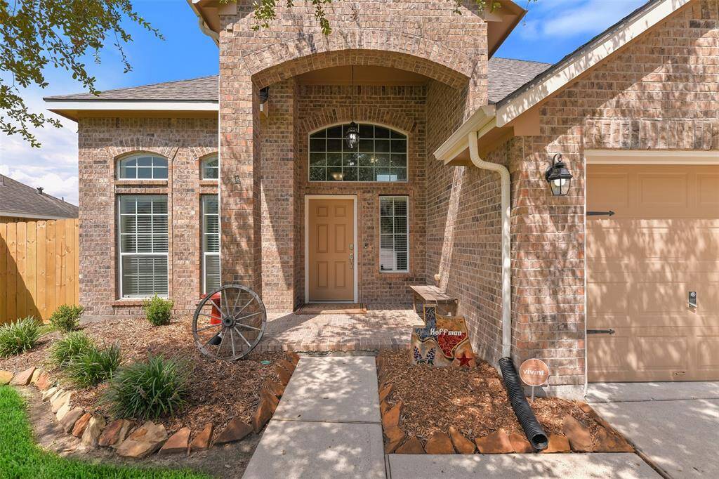 A welcoming brick porch with arched windows and keystones gives this front elevation an upscale look.