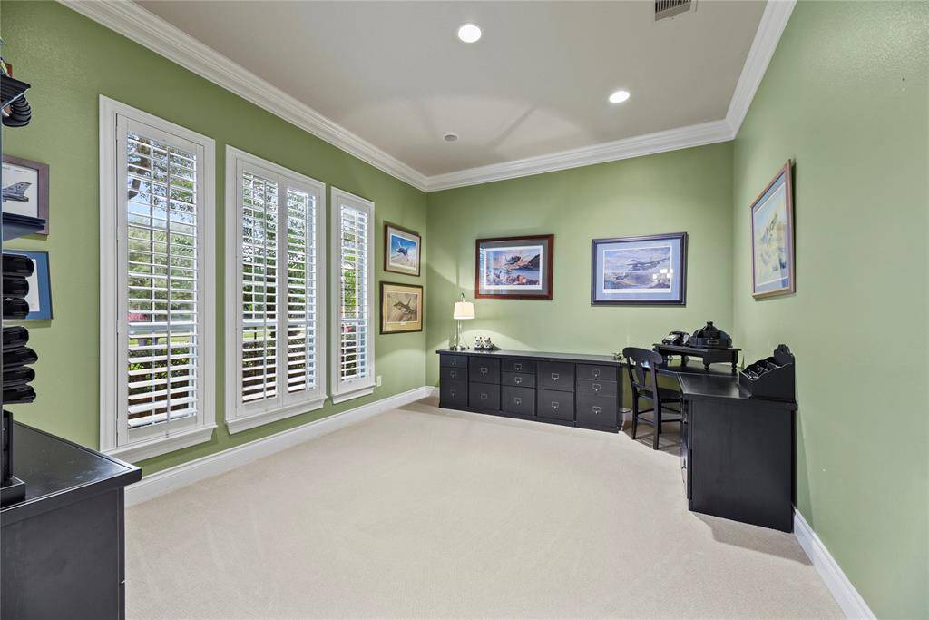 Spacious Library / Study with view of mature oak trees that shade the front yard and wooden shutters that let in the afternoon and evening glow of the sun.