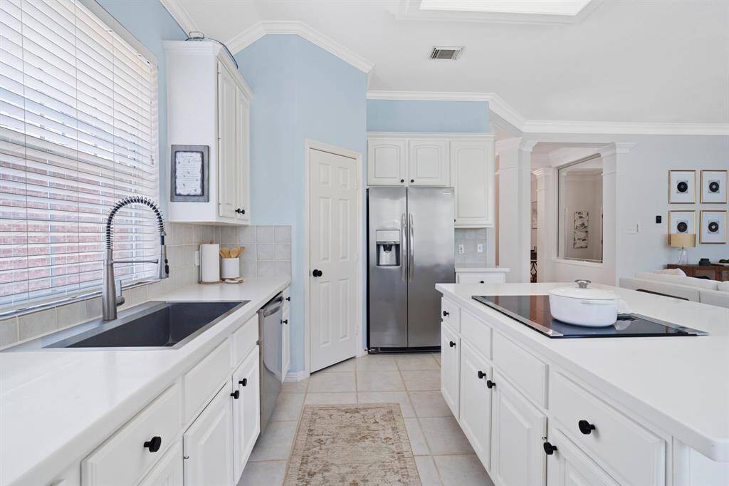 The kitchen features white cabinets,creating a clean and timelessaesthetic.