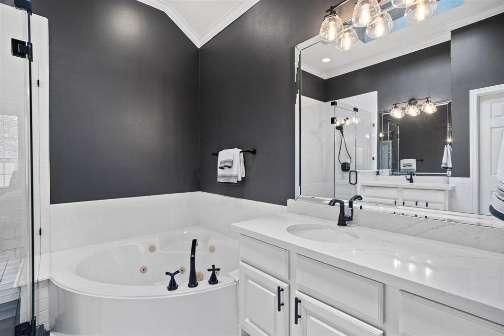 The primary bathroom also has custom paint and crown molding.