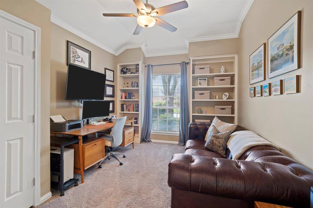 Third bedroom features a largewindow, custom paint, crown molding, built-in shelving, and plush carpet.