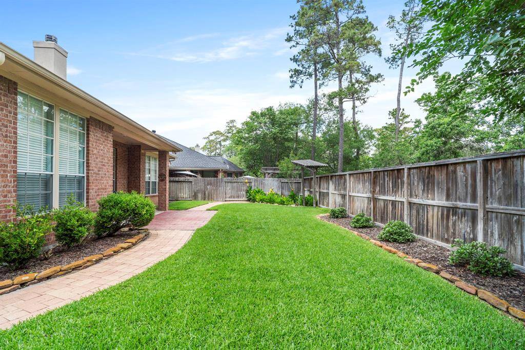 There is plenty of green space and a paved walkway in the backyard.