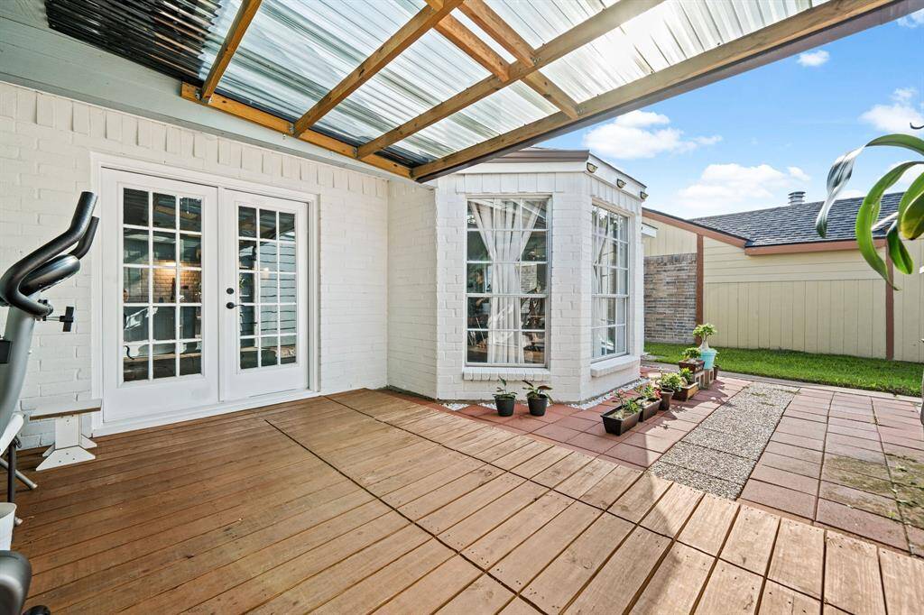 Covered patio with wood decking, and garden space—perfect for relaxing or outdoor fun