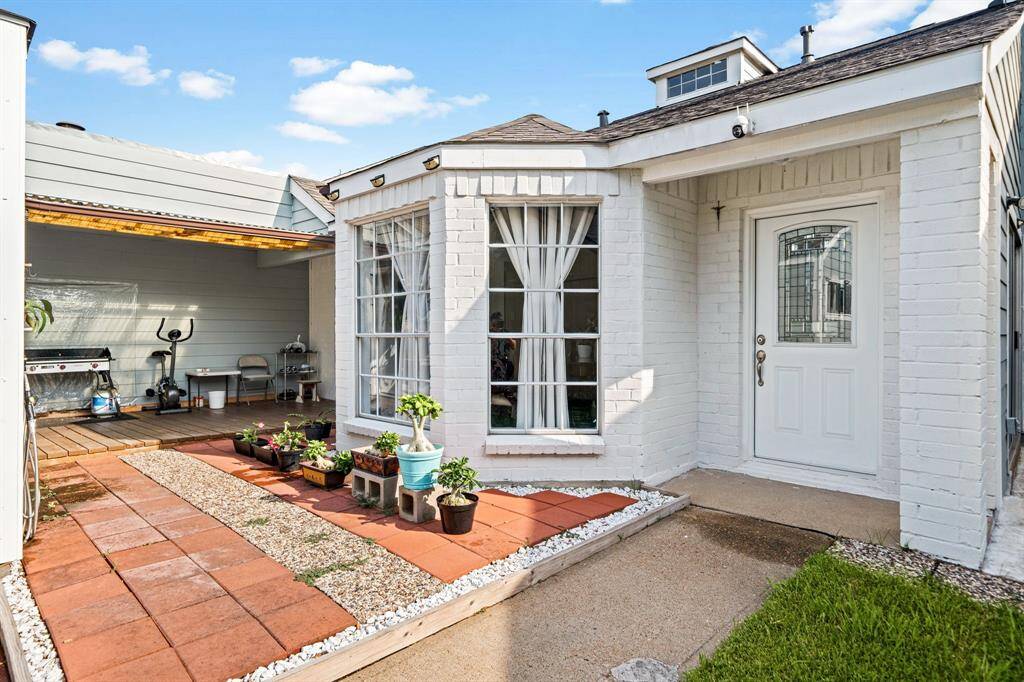 Inviting tiled walkway and garden space leading to the covered patio—perfect for relaxing.