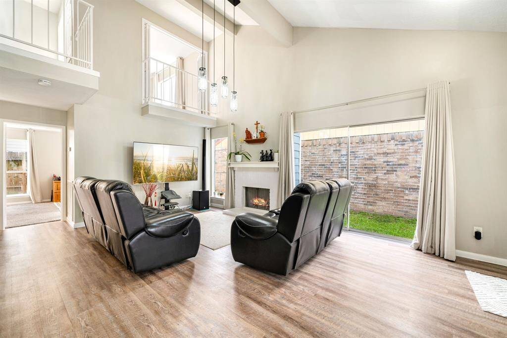 Soaring ceilings, a cozy fireplace, and large windows fill the space with natural light.