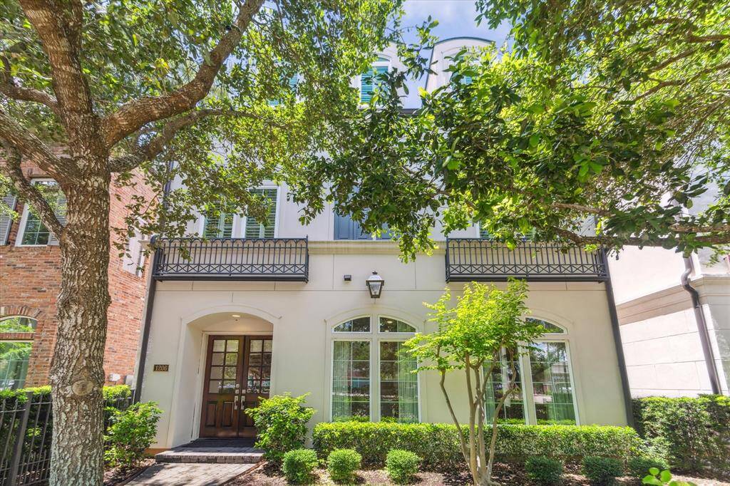 Charming single family home with a classic facade featuring arched windows and a covered entrance. A small, well-maintained garden and mature trees provide shade and privacy.