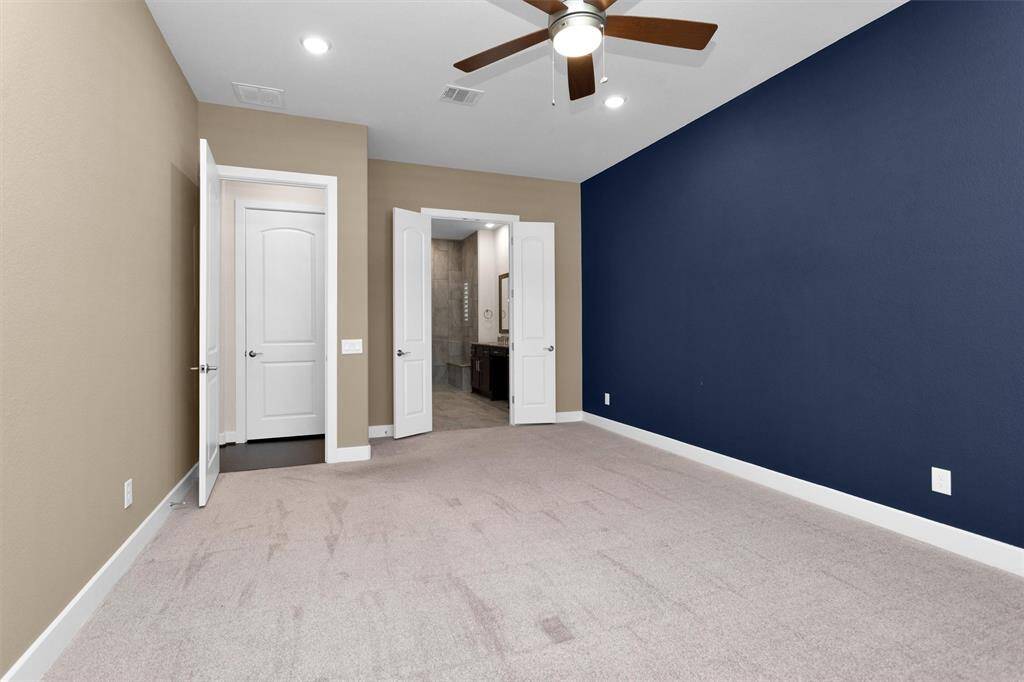 A serene primary bedroom featuring ample space, large windows, and a comfortable, private atmosphere.