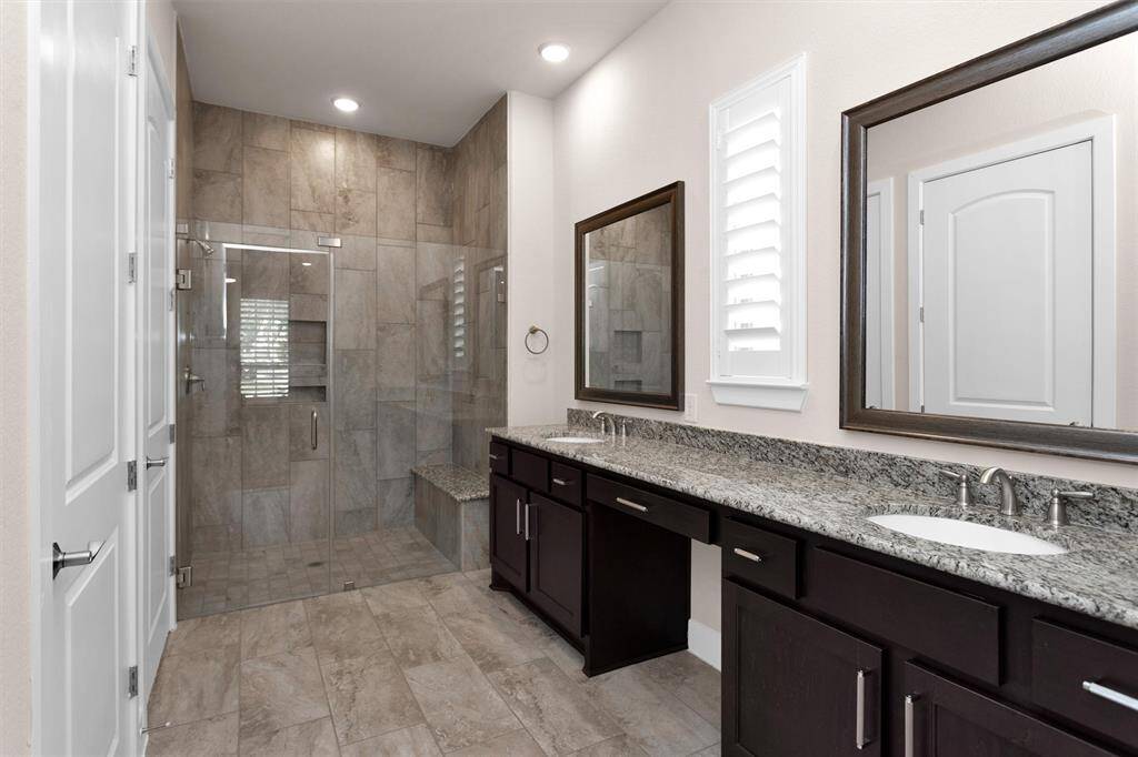 A luxurious bathroom with double sinks and walk-in shower, designed for comfort and style.