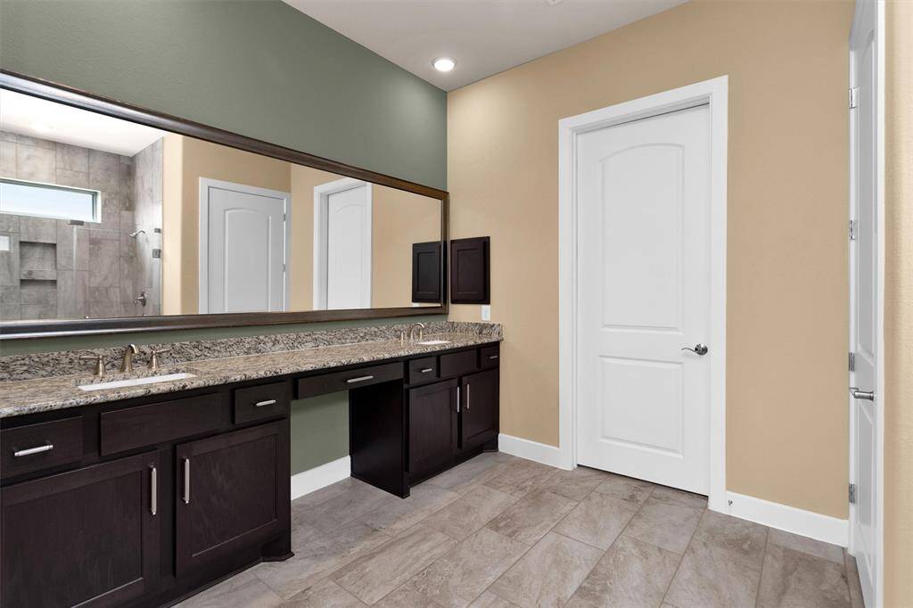 A well-appointed bathroom featuring double sinks with elegant countertops, a spacious walk-in shower with modern tilework, and stylish fixtures.