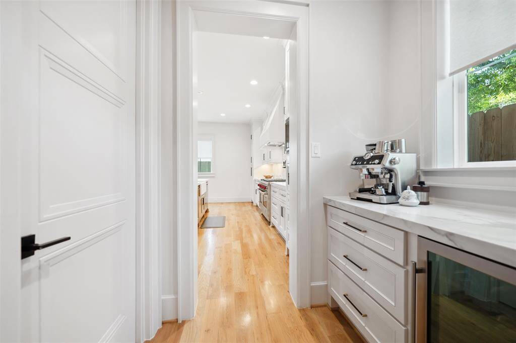 Butler's Pantry offers additional counter space for appliance or dish setting. Beverage Fridge is built-in w/ additional pot/pan drawers. Mudroom to the right from garage entrance.