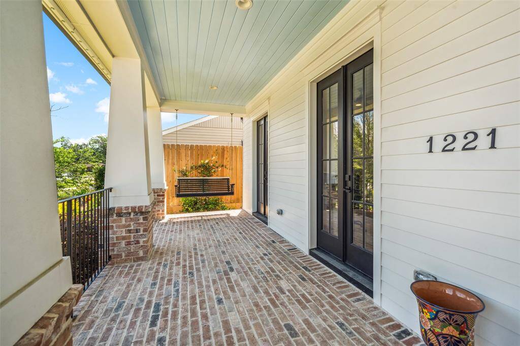 Brick front porch offers an inviting entry with a classic porch swing.