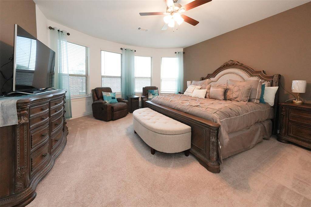 Warm and inviting primary bedroom with a charming bay window sitting area—perfect for relaxing—with plenty of space for a king-size bed.