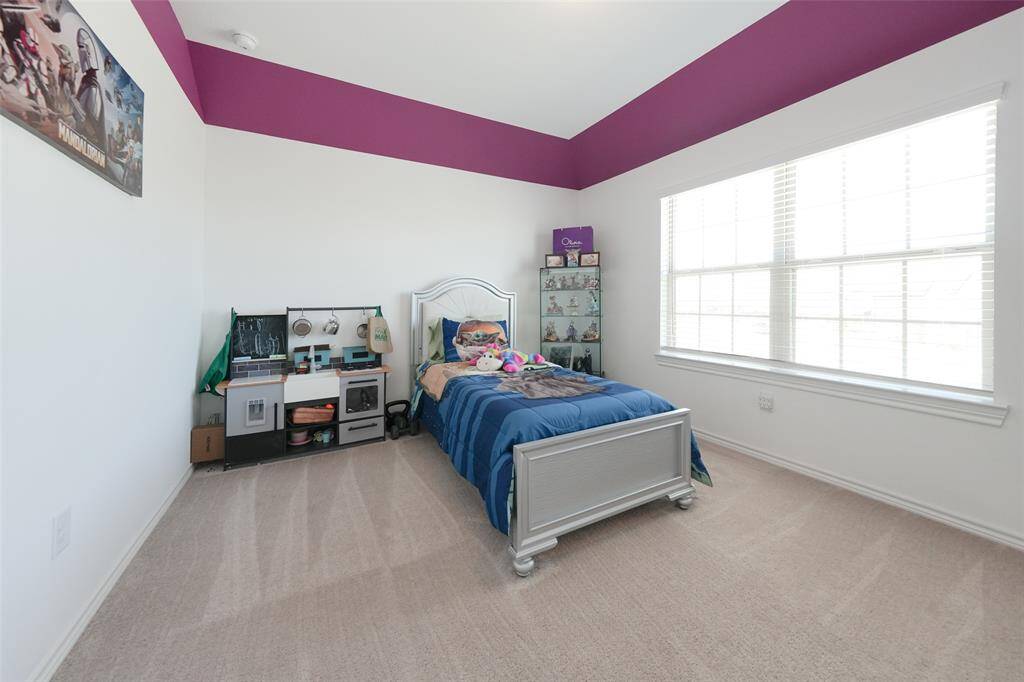 Large, welcoming bedroom with a bright view of the street, offering plenty of space for comfort and personalization.