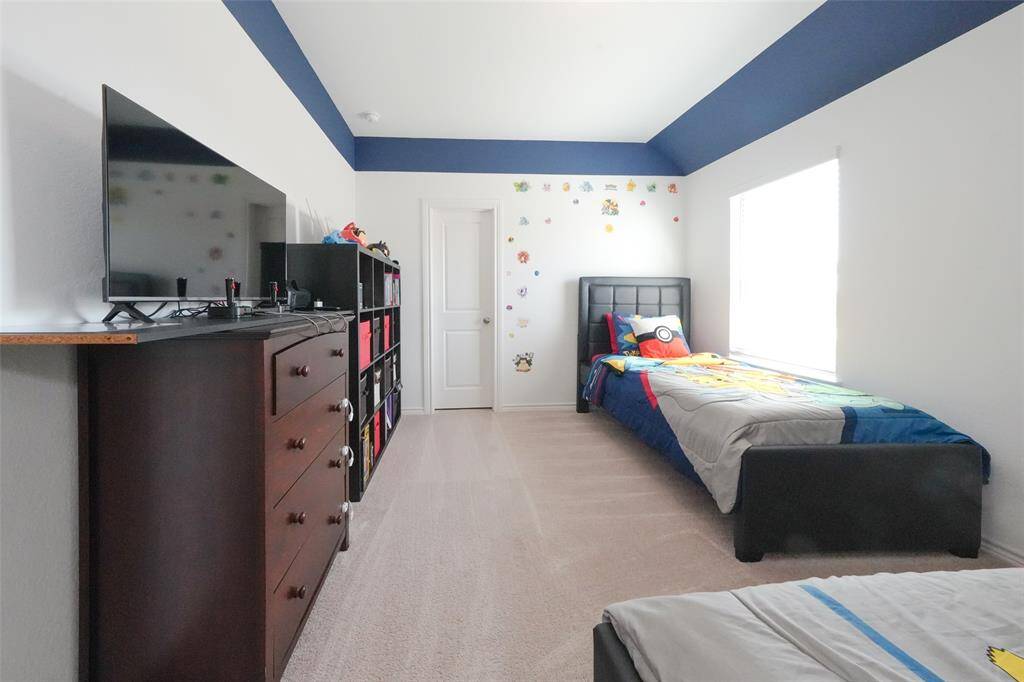 Large bedroom with ample space for two beds, complete with a walk-in closet for extra storage.