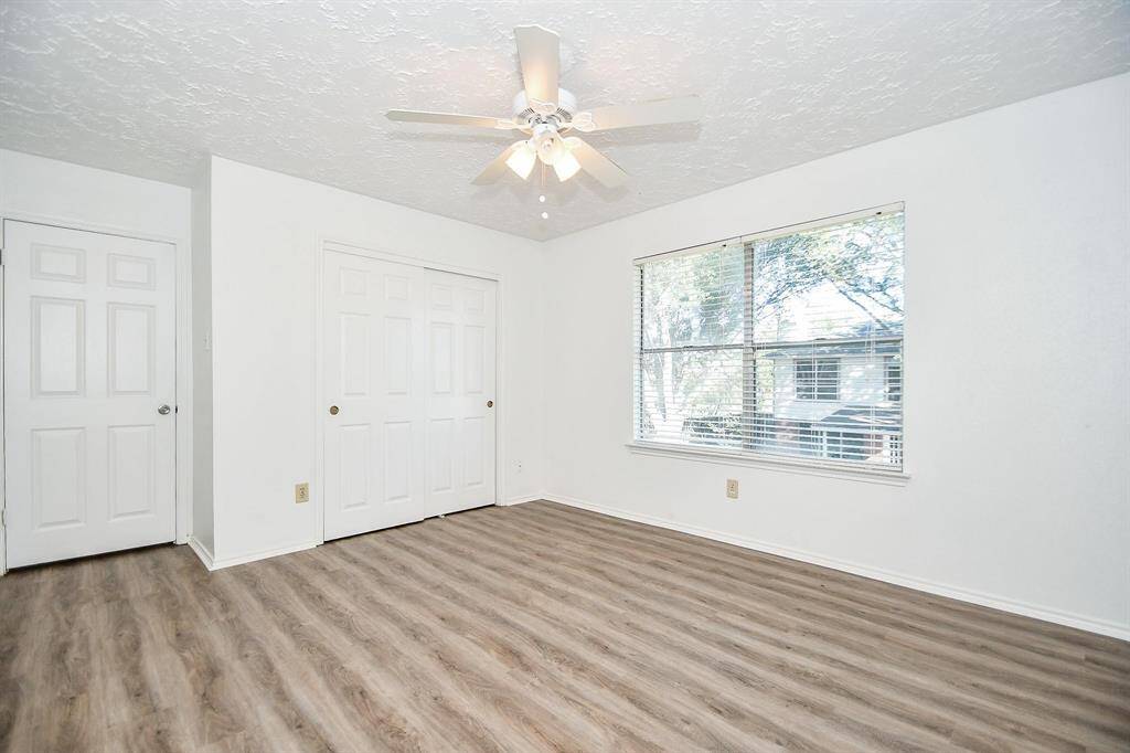 Second of four bedrooms with natural light and ceiling fan