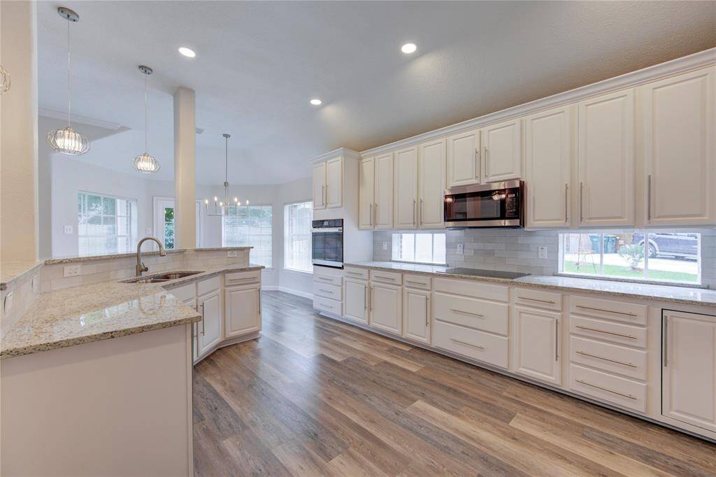 This amazing kitchen has a ton of cabinets, all new granite counters, new appliances, new sink and faucet, a stylish new backsplash and new LED recessed lighting.