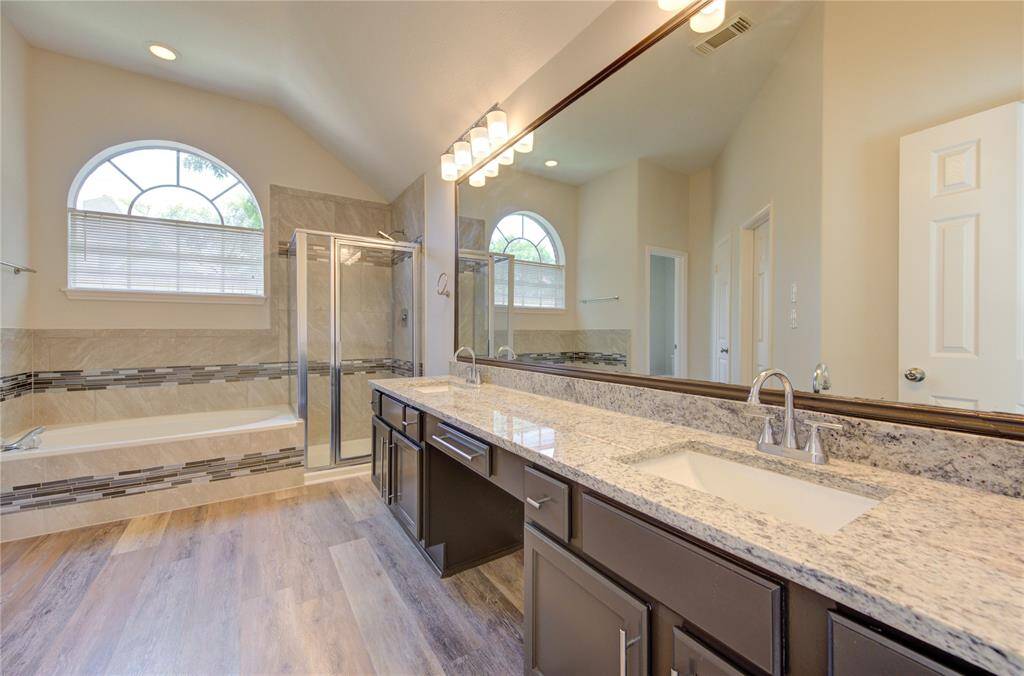 The primary bath si stunning!  It has all new granite with new sinks and faucets, a newly tiled shower and tub surround with glass mosaic details, new light fixtures and new stylish cabinet door pulls.
