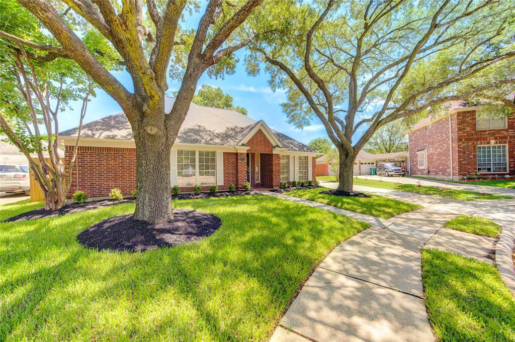 This lovely home is flanked with 2 beautiful oak trees, nicely trimmed so that you can see the home.