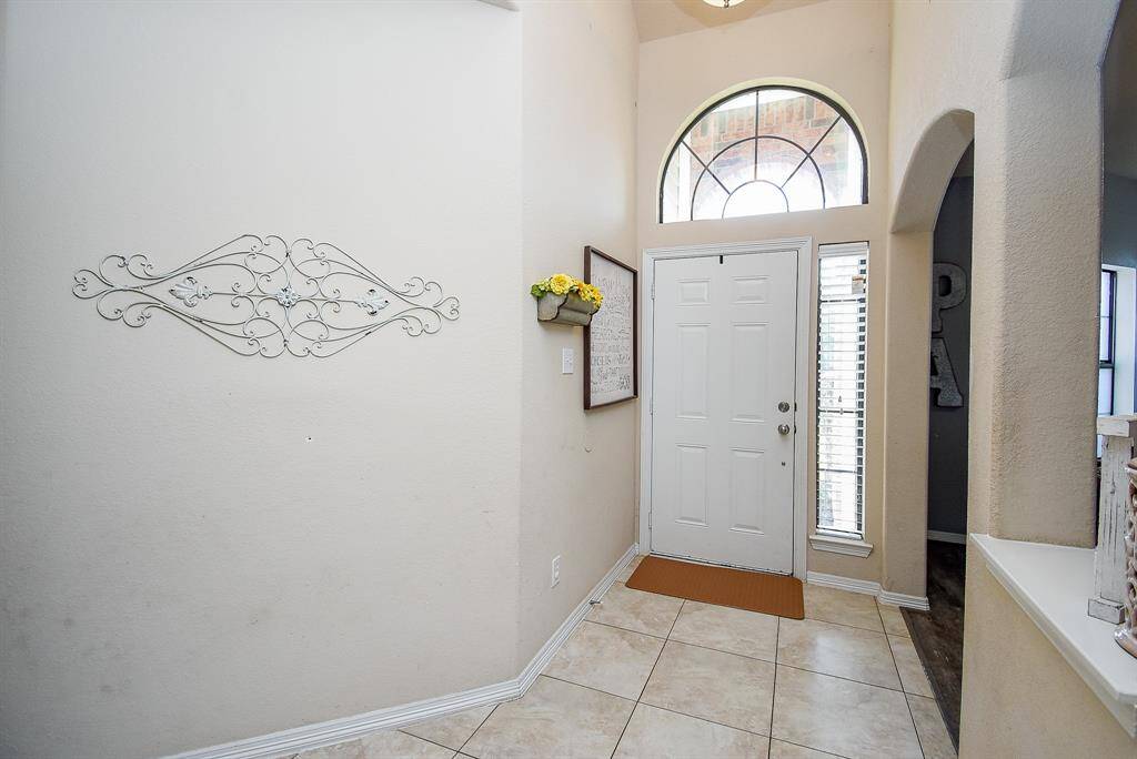 Tiled entry with high ceiling. The formal dining to the right is currently used as aTV/Flex playroom.