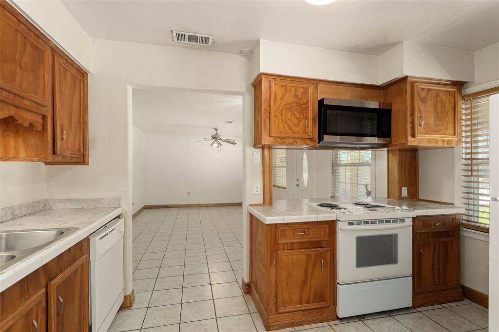 The kitchen located in between living room & dining room