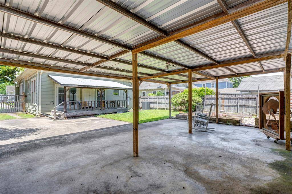 View of back porch from carport.  Raised flower beds in background.