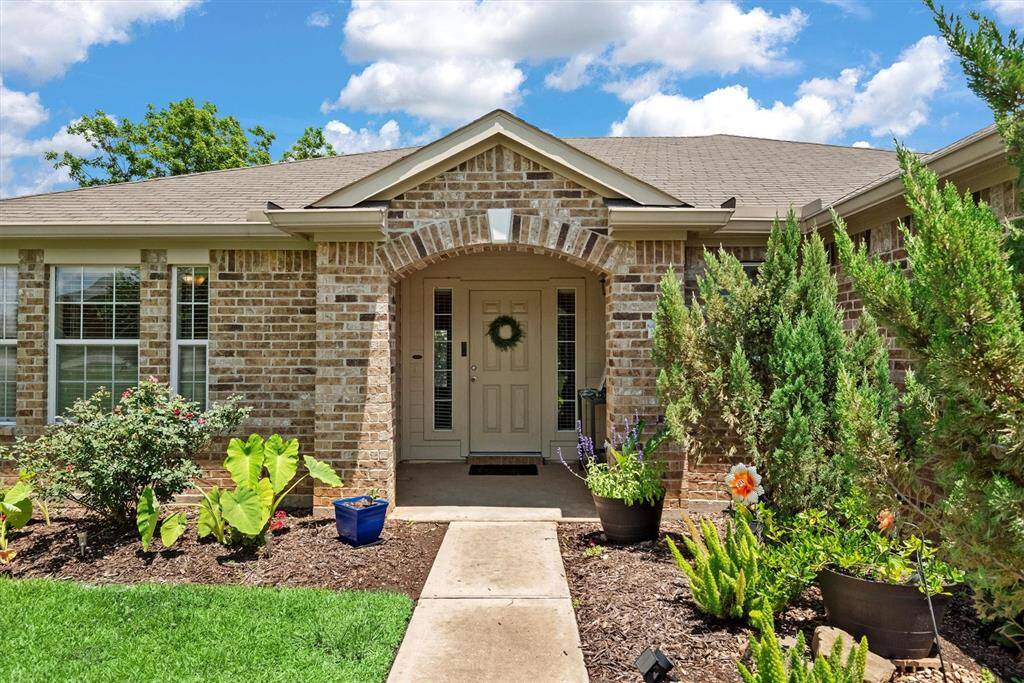 Charming front porch and vibrant gardens.