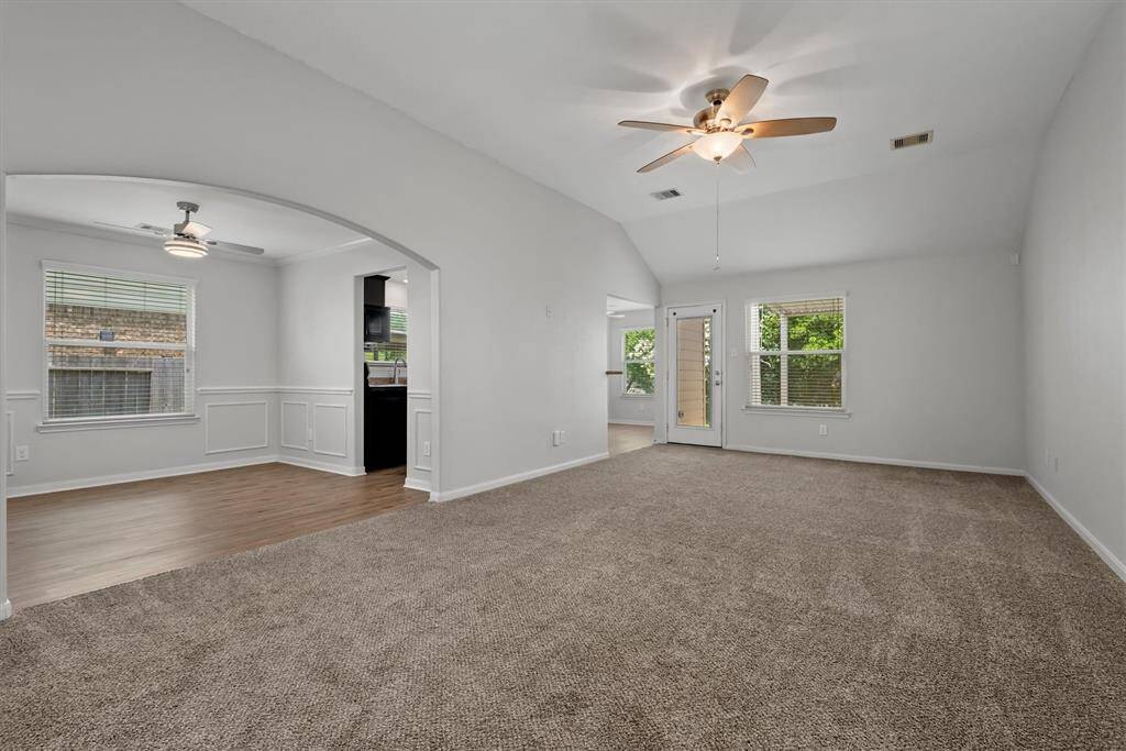 Living room is open to formal dining featuring luxury vinyl plank flooring.