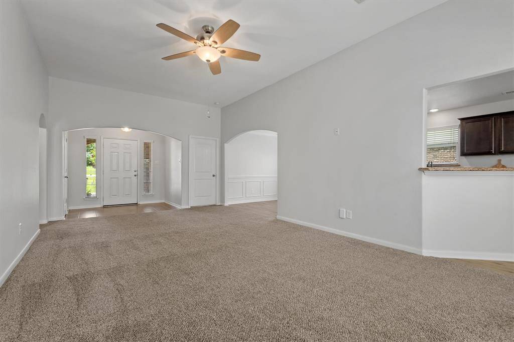 Another angle of the living room showing a door to the front secondary bedroom.