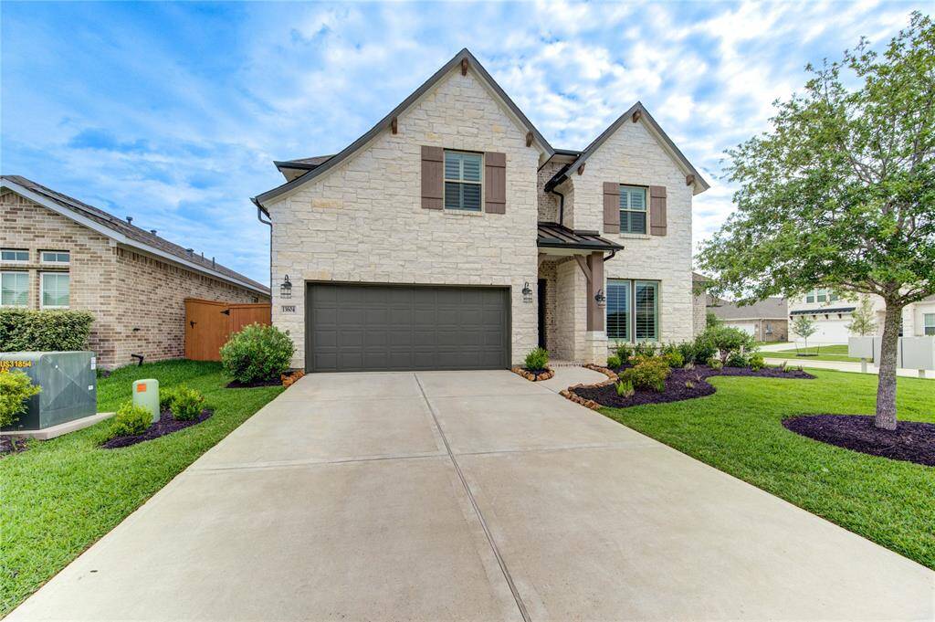 Charming stone exterior with manicured landscaping and a spacious driveway. Ideal curb appeal.