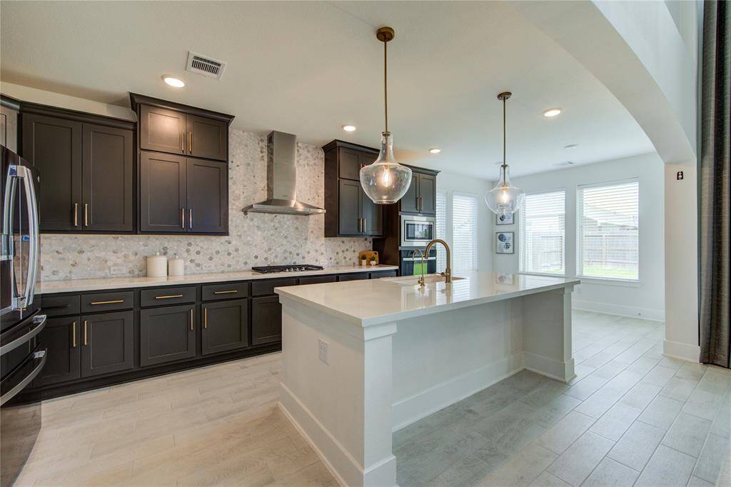 Spacious kitchen featuring sleek quartz countertops, a gas cooktop, and built-in microwave and oven.