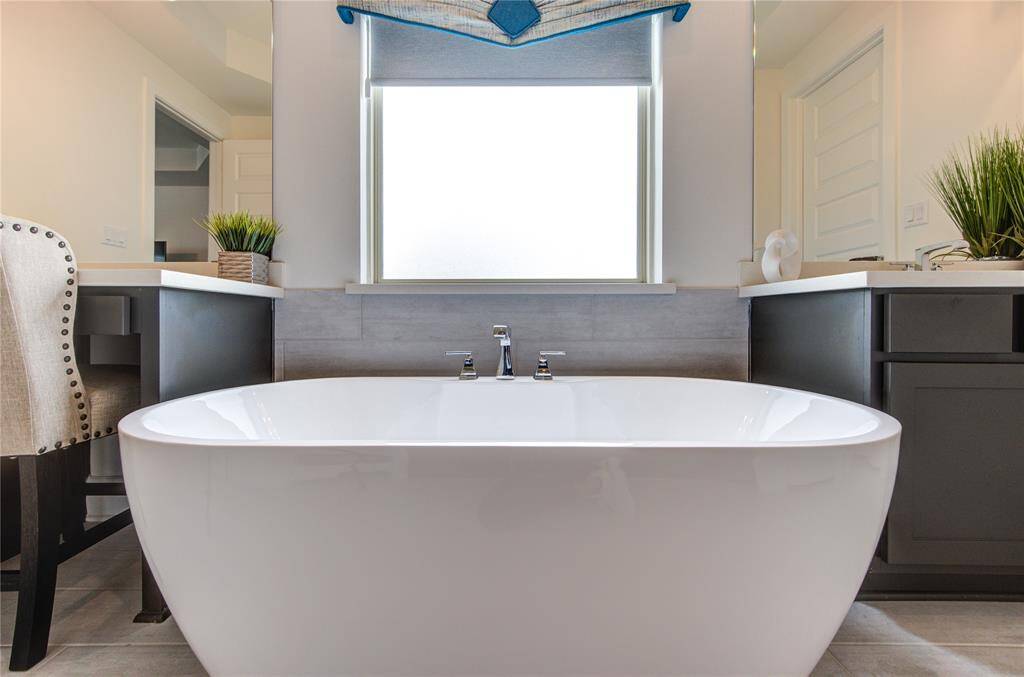 Luxurious soaking tub with custom electric shutters for ultimate privacy.