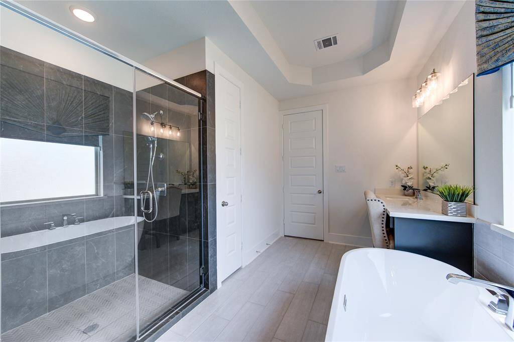 Luxurious bathroom with a separate tub and glass-enclosed shower for ultimate relaxation.