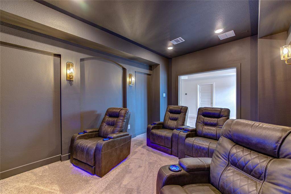 Experience ultimate entertainment in this luxurious media room, featuring plush seating and elegant lighting for the perfect movie night.