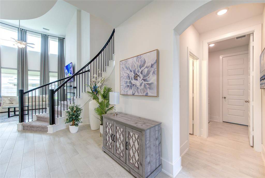 Welcome to elegance and style. This spacious entryway features high ceilings, a graceful curved staircase, and abundant natural light, setting the tone for the rest of the home.