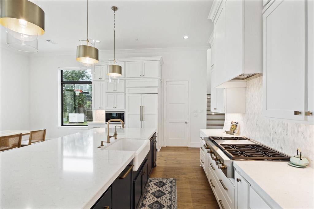 The kitchen is enhanced by a charming apron-front sink and convenient drawer stacks located beneath the range for easy access and organization.