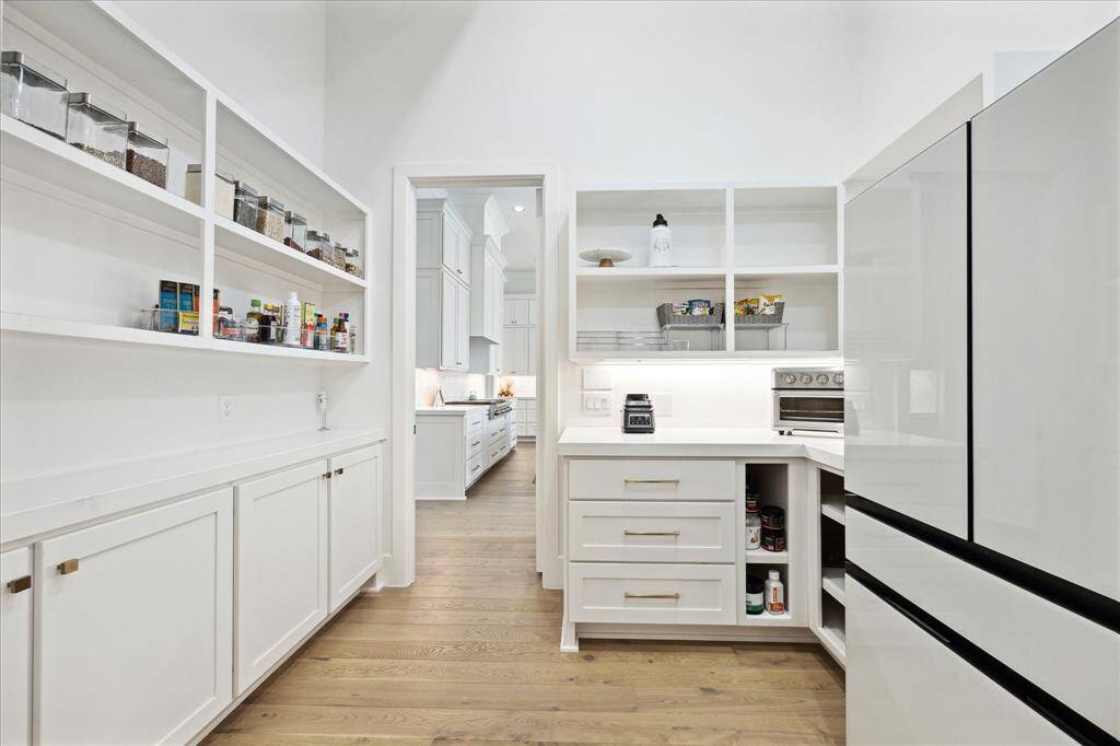 The spacious walk-in pantry is outfitted with custom built-ins and offers ample room for an additional refrigerator.